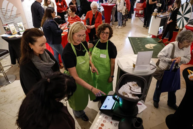 Ausstellende bereiten Speisen an einem Stand mit einem Kochgerät zu