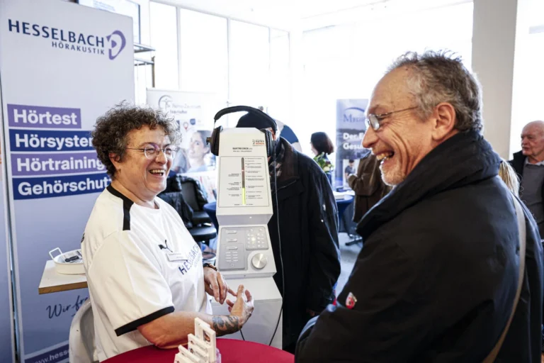 Zwei Personen führen ein Gespräch an einem Informationsstand