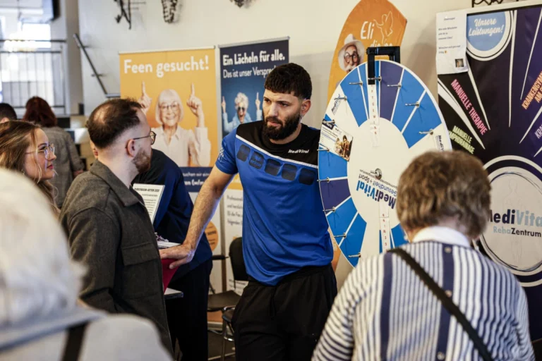 Aussteller erklärt ein Angebot an einem Stand mit Glücksrad