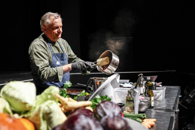 Zwei Personen bereiten Speisen an einem Stand zu