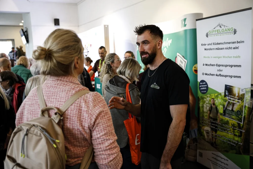 Aussteller spricht mit einer Besucherin an einem Informationsstand beim Iserlohner Gesundheitstag